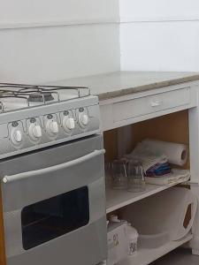 a kitchen with a stove and a white counter top at Departamento impecable. con cochera in Luján