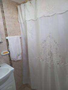 a bathroom with a shower with a white shower curtain at Departamento impecable. con cochera in Luján