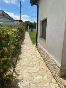 a stone walkway next to a building with a window at Casa moderna in Mineri in Mineri