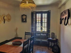 a dining room with a table and a clock on the wall at Casa Maria in Terras de Bouro