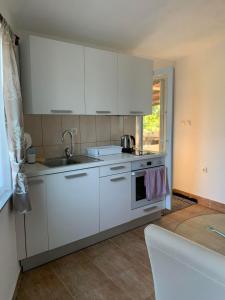 uma cozinha com armários brancos e um lavatório em Kuca za iznajmljivanje ANDRIJA em Ljubuski