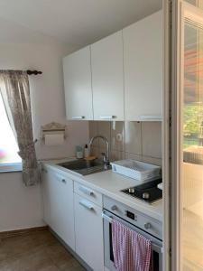 a kitchen with white cabinets and a sink at Kuca za iznajmljivanje ANDRIJA in Ljubuški
