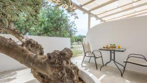 a patio with a table and a tree at Fantasy Rooms in Adamantas