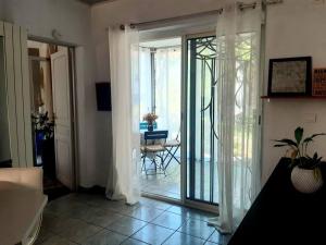 a living room with a sliding glass door to a patio at Charmante maison de ville avec jardin in Perpignan