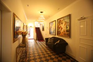 a hallway with a couch and paintings on the wall at WEISSES ROSS DESIGNHOTEL in Kirchheimbolanden