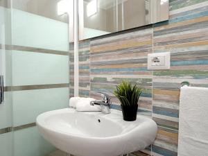y baño con lavabo blanco y espejo. en Monolocali Cavour - Affitti Brevi Italia, en Ulassai