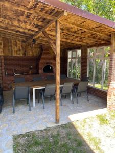 a patio with a table and chairs under a wooden pergola at Casa moderna in Mineri in Mineri