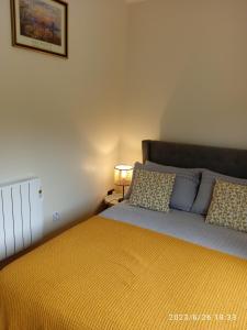 a bedroom with a large bed with a yellow blanket at Nire Valley Cottage 