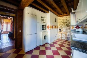a kitchen with a washing machine and a checkered floor at Casa Rural Álamo Grande in Layos