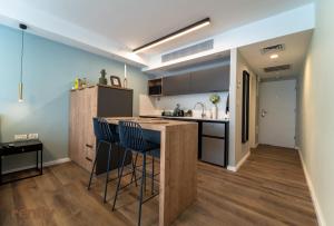 a kitchen with a counter and chairs in a room at Sea side "Tulip" apartment - by Rently in Eilat