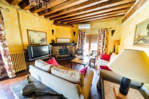 - un salon avec deux canapés et une télévision dans l'établissement Casa Rural Álamo Grande, à Layos