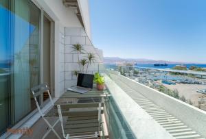 a balcony with a laptop sitting on a table on a building at Sea side "Tulip" apartment - by Rently in Eilat