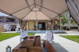 a wooden table and chairs under a large umbrella at Pilot's Cottage Villa With Sea View in Tavronitis