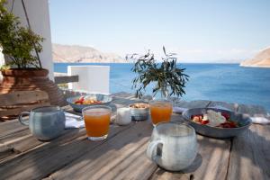 a wooden table with food and drinks on top of it at The Anchor House in Symi