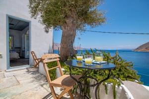 a table and chairs on a patio with a view of the water at The Anchor House in Symi