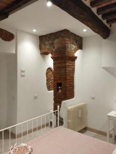 a room with a brick fireplace and a staircase at Casa Erica in Cortona