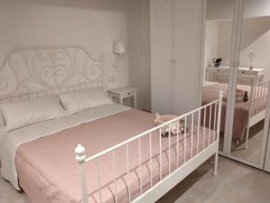 a white bedroom with a crib and a bed at Casa Erica in Cortona