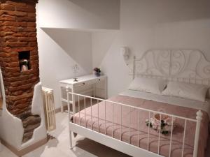 a bedroom with a white bed and a brick wall at Casa Erica in Cortona