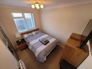 a small bedroom with a bed and a window at Bungalow a few minutes from the sea. in The Mumbles