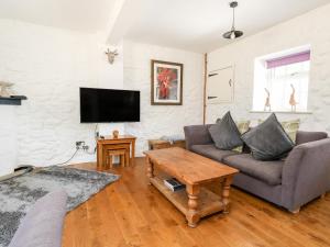 a living room with a couch and a table at Magnolia Cottage Osmington in Osmington
