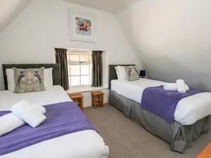 a bedroom with two beds and a window at Magnolia Cottage Osmington in Osmington