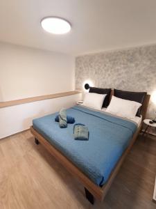 - une chambre avec un grand lit et une couverture bleue dans l'établissement City Center Loft, à Kavala