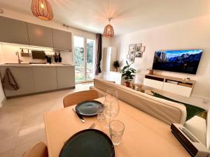 una sala de estar con una mesa con copas de vino. en Paisible studio tout neuf en lisière de forêt, en Peyrolles-en-Provence