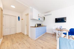 a kitchen and dining room with a table and chairs at Balaton Wave Apartments in Balatonalmádi