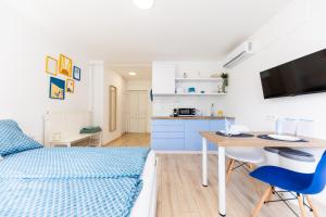Habitación con cama, escritorio y cocina. en Balaton Wave Apartments, en Balatonalmádi