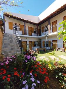 a building with flowers in the yard at Pouso Casa da Vovó in Tiradentes