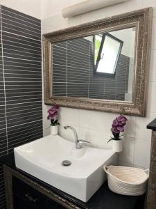 a bathroom with a white sink and a mirror at וילה מפנקת ומאובזרת במיקום מעולה in Giv'at Avni