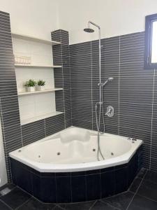 a bath tub in a bathroom with a shower at וילה מפנקת ומאובזרת במיקום מעולה in Giv'at Avni