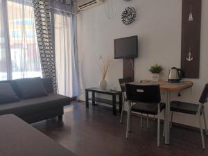 uma sala de estar com um sofá e uma mesa com cadeiras em APARTMENT STUDIO DELUXE MARINA CAPE 4 stars resort 33 5 em Aheloy