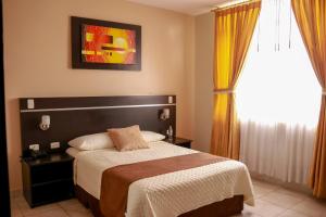 1 dormitorio con cama y ventana en Hotel Golden Vista, en Santo Domingo de los Colorados