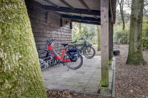 Duas bicicletas estão estacionadas ao lado de um edifício em B&B Wicherumloo em Wekerom