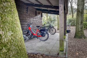 dos bicicletas están estacionadas al lado de un edificio en B&B Wicherumloo en Wekerom