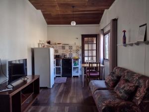 sala de estar con sofá y cocina en Casas Porto Belo, um recanto a 100 metros da praia, en Porto Belo