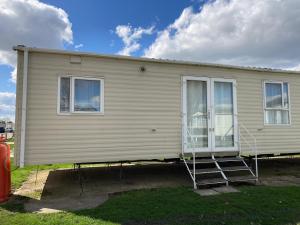 un mobile home avec une terrasse couverte et une maison dans l'établissement Luxury 8 and 6 berth caravans, à Jaywick Sands