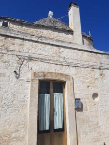 a brick building with a door with a window at Trullo Chiancola Antica in Alberobello