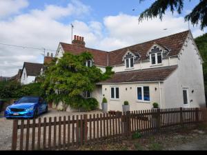 ein blaues Auto, das vor einem weißen Haus parkt in der Unterkunft Eastfield cottages in Devizes