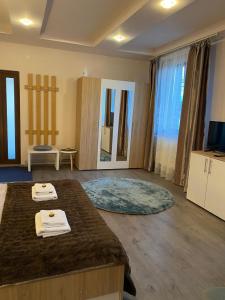 a bedroom with a large bed with towels on it at Casa Diana in Mihai Viteazu