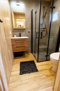 uma casa de banho com um chuveiro, um lavatório e um WC. em Letnie Chatki Nowe Guty em Nowe Guty