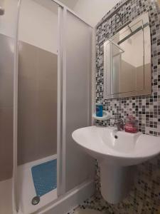 La salle de bains est pourvue d'un lavabo et d'une douche avec un miroir. dans l'établissement East Breeze Penthouse, à Mġarr