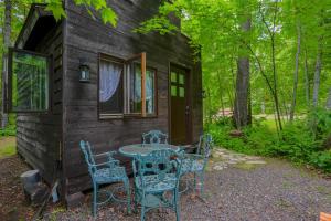a table and chairs outside of a cabin at Vintage Wild West Tiny Hotel in the Woods! in Pine City