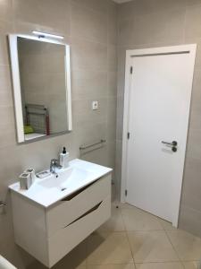 a bathroom with a white sink and a mirror at Casa da Ponte de Pedra in Aljezur