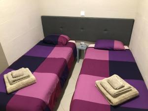 two beds in a room with purple and purple sheets at Casa da Ponte de Pedra in Aljezur