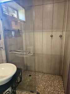 a shower with a glass door next to a sink at Imoflo in Haenertsburg