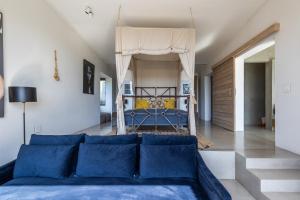 a living room with a blue couch and a bed at The One in Knysna