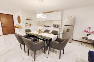 a dining room with a table and chairs and a kitchen at Siqueiros Maia Home - Lujoso apto en Polanco cerca de Antara 3BR in Mexico City