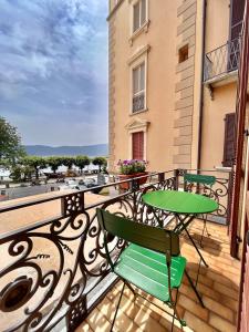 d'un balcon avec une table et des chaises vertes. dans l'établissement Casa Gambusso historical house magnificent Lake View, à Verbania